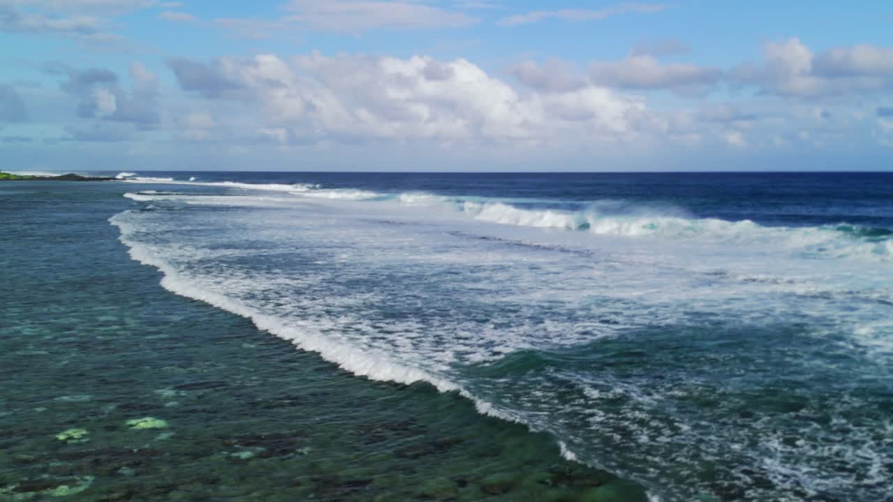 Waves roll over shallow reef waters off St. Felix Beach, Mauritius. Aerial shot captures ocean texture, reefline, and sky, ideal for themes of nature, clarity, and marine environments.
