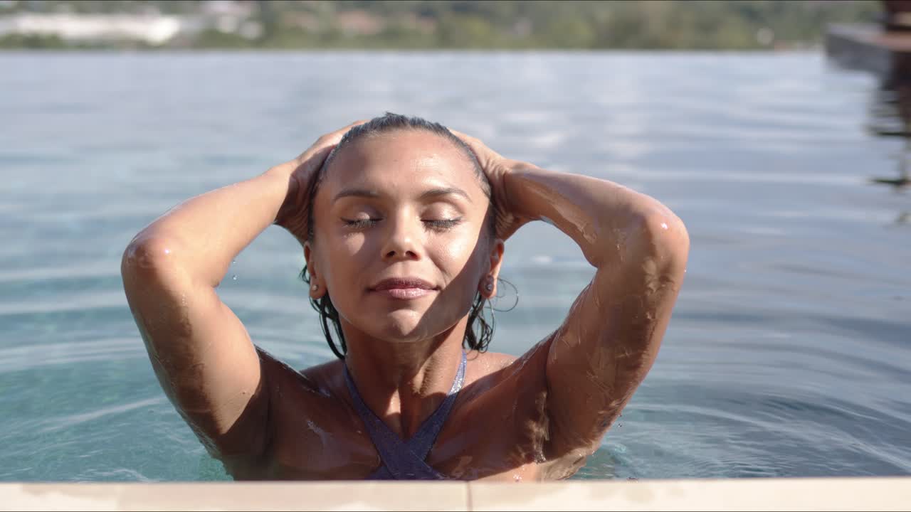 mujer adulta satisfecha descansando en la piscina en un día soleado