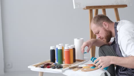 a young artist at work he works with inspiration paints a picture happy to do what he really likes - a young artist at work, he works with inspiration, paints a picture, happy to do what he really likes
