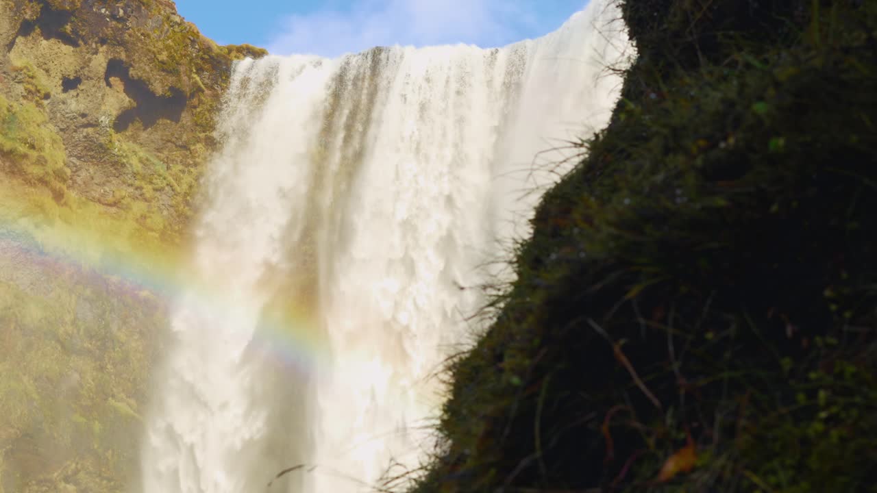 gran cascada con un arco iris que la atraviesa durante el día