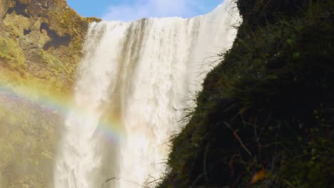 large waterfall with a rainbow going across it during daytime