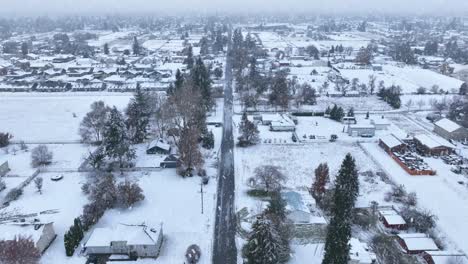 Aerial-view-of-rural-Spokane,-WA-with-snow-actively-falling-on-the-community