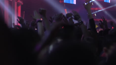 Crowd-of-excited-music-fans-with-hands-up-at-the-concert