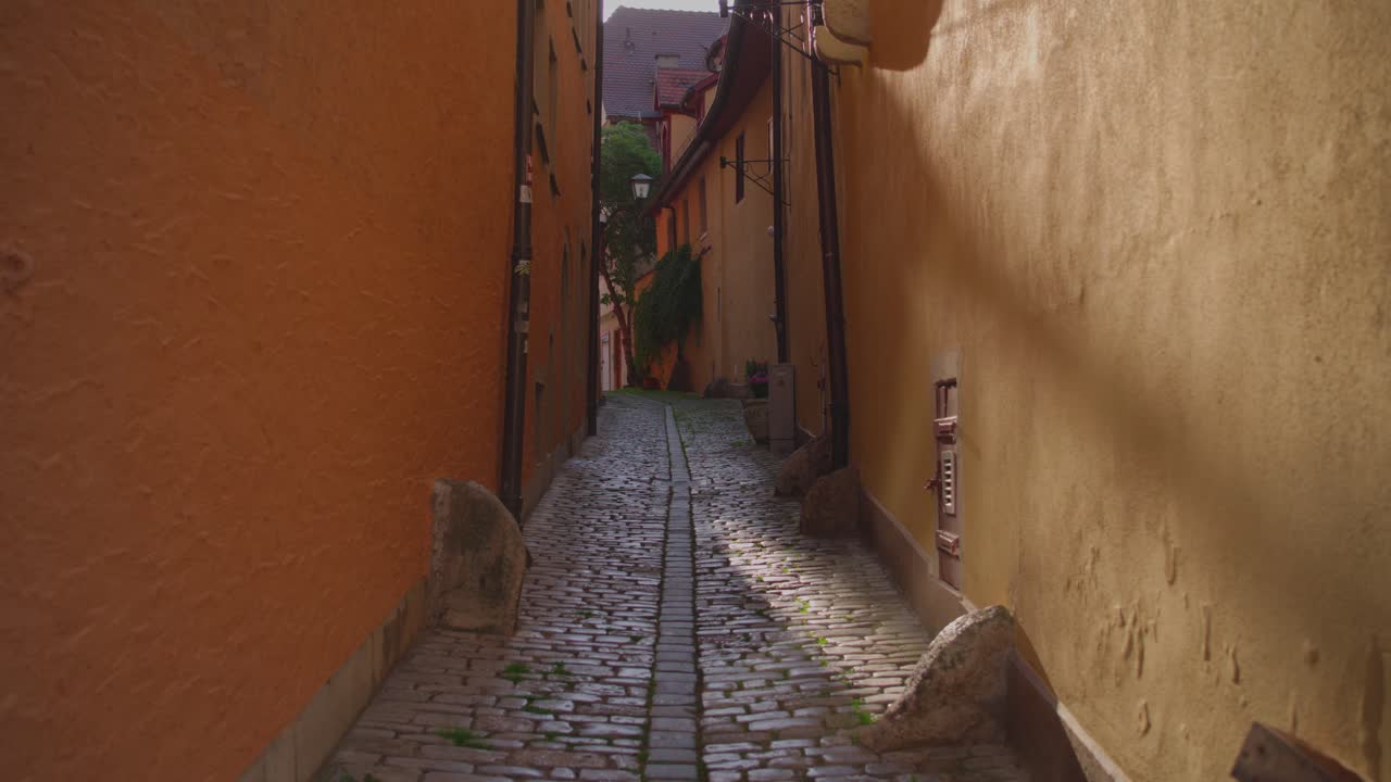 Narrow cobblestone alley with colorful buildings in the medieval town of Rothenburg ob der Tauber, Bavaria, Germany