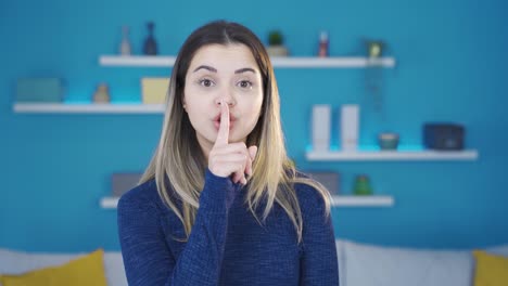 young woman says shhh to camera.