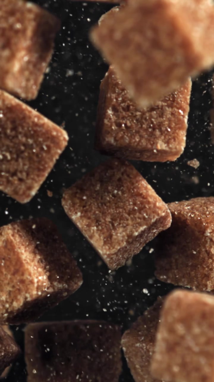 Brown Sugar Cubes Falling in Slow Motion on a Dark Background