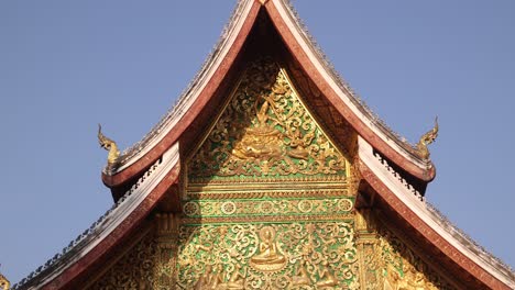 green and gold exterior of buddhist temple in luang prabang, laos traveling southeast asia