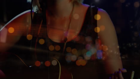 animation of blurred night road traffic over caucasian woman playing guitar on concert