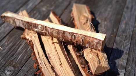 leña de abedul sobre una mesa de madera rústica con una hermosa luz - cierre de piezas de madera sobre una mesa con textura cruda lista para usar - portátil en cámara lenta