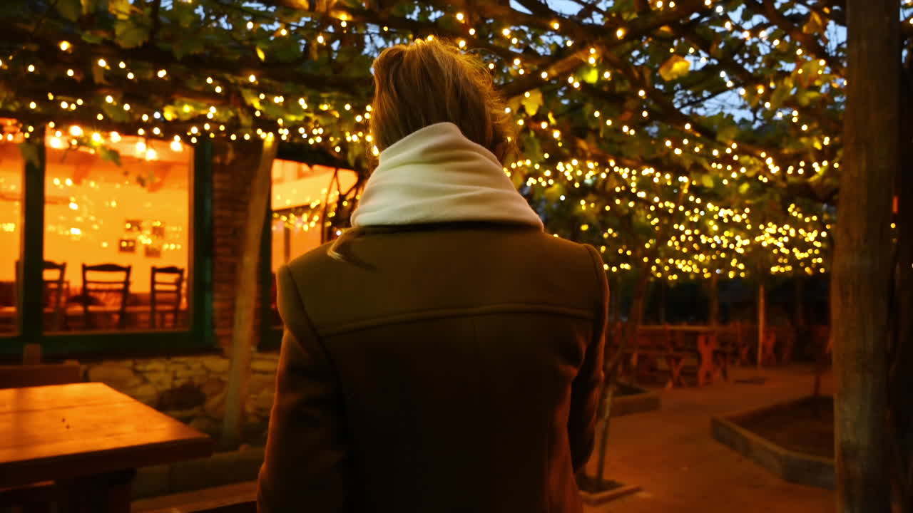Woman at a terrace with christmas decorations at night