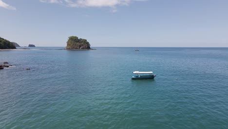 Paneo-Aéreo-Hacia-Adelante-Sobre-Dos-Pequeños-Barcos-De-Pesca,-Estáticos-En-El-Océano,-Anclados