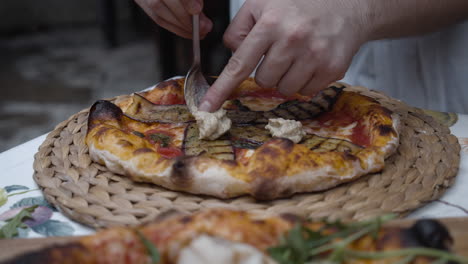 chef puts humus topping onto neapolitan pizza