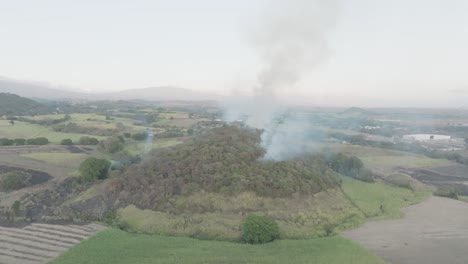 un leve incendio forestal en una colina en un día nublado, el humo listo para estallar en llamas