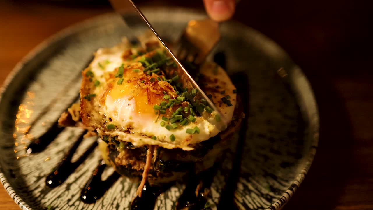 포크와 칼로 달 노른자 접시를 잘라