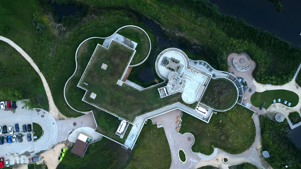 Overhead drone frames circular eco building with grass roof