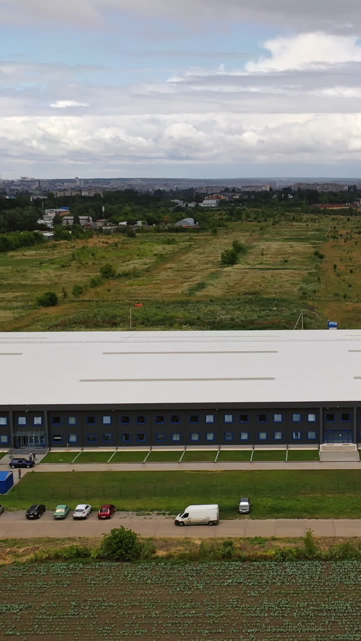 Modern distribution center from above. Aerial view of warehouse storage of industrial factory Vertical video