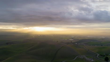 forward dolly of moody clouds at sunset and winding road passing through rolling hills