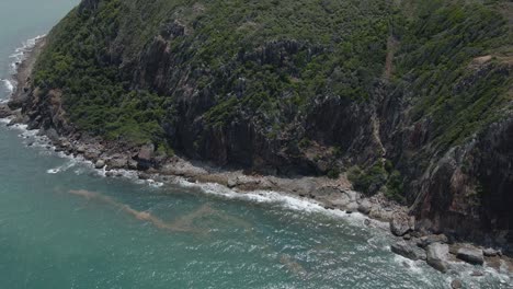 Rugged-And-Rocky-Shoreline-Hit-By-Calm-Waves-At-Summer---Turtle-Lookout-In-QLD,-Australia