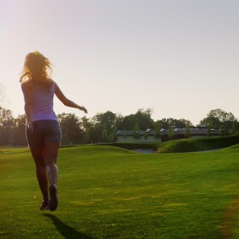 Silhouettes-of-carefree-young-woman-running-on-the-lawn-at-sunset