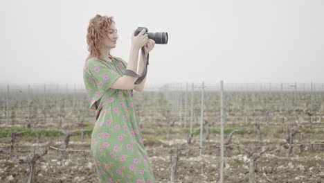 woman photographing a vineyard landscape