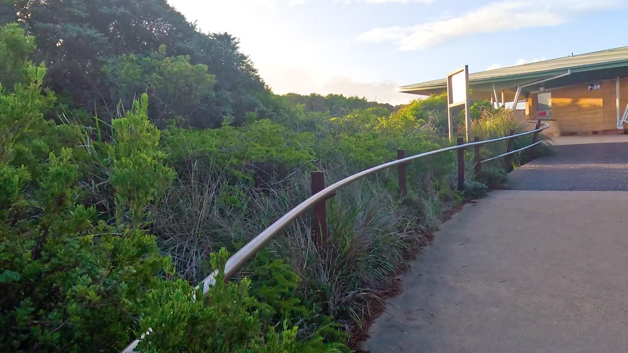 울창한 해안 식물 가운데 방문자 센터로 이어지는 경치 좋은 산책로