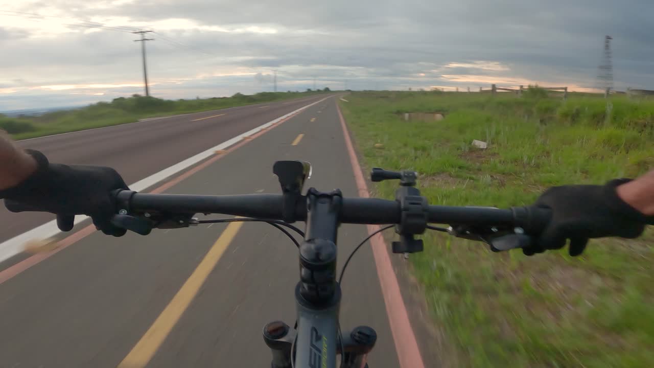 ciclista montando en el carril bici al lado de la carretera, video en primera persona