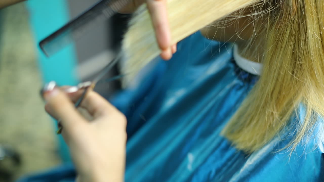 Una bella donna che si fa tagliare i capelli dal parrucchiere nel salone di bellezza