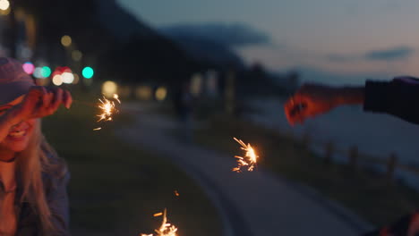 friends playing with sparklers celebrating new years eve teenage girls dancing having fun evening with sparkler fireworks sharing celebration at night