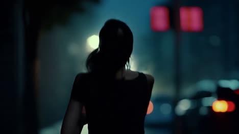 woman running through a city at night