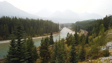 cargo train at canadian pacific railway in morant's curve in alberta, canada with view of bow river from bow valley parkway - time lapse