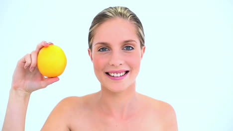 Cheerful-woman-holding-an-orange-in-her-hand