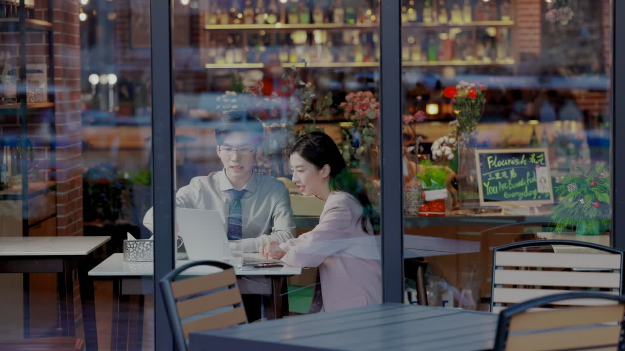 Two Young coffee shop owner and business team meeting work together in project brainstorming using a laptop. Startup teamwork concept colleagues discussing planning for success