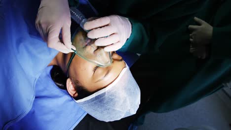 surgeon putting oxygen mask on patient in operation room