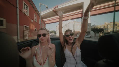 women enjoying a convertible ride in the city