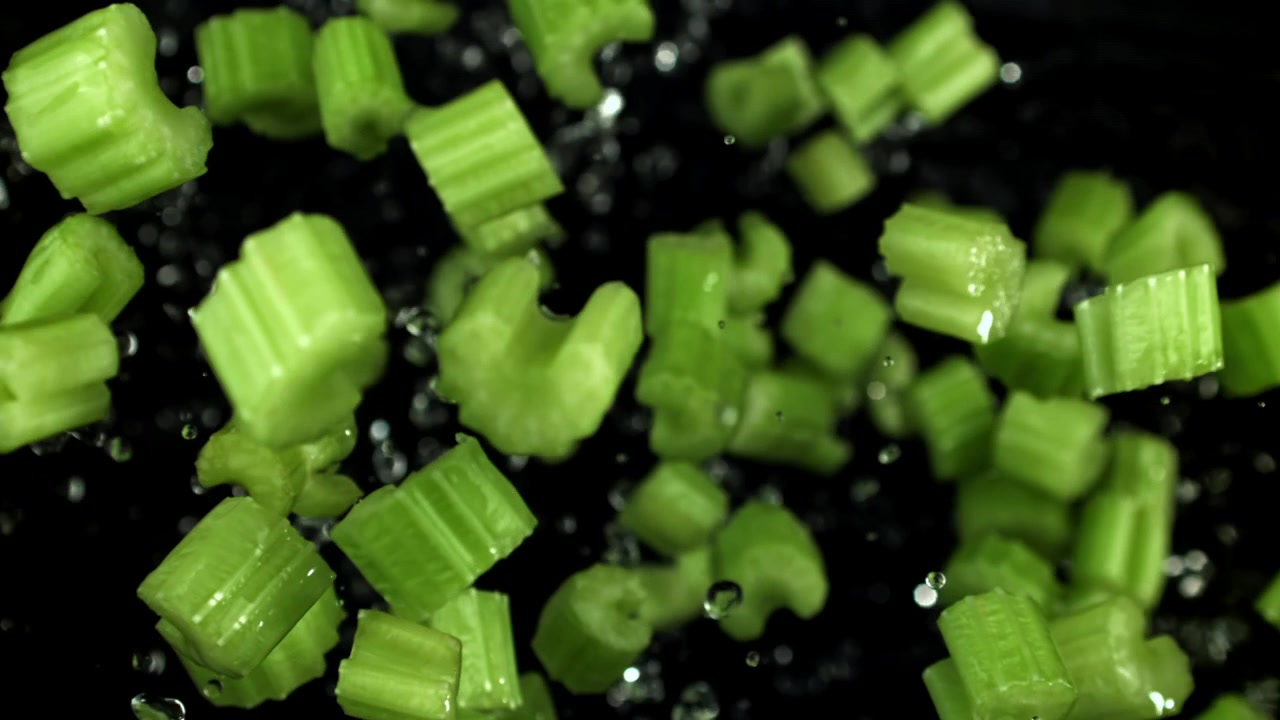 Green Celery Pieces and Water Droplets Falling in Slow Motion