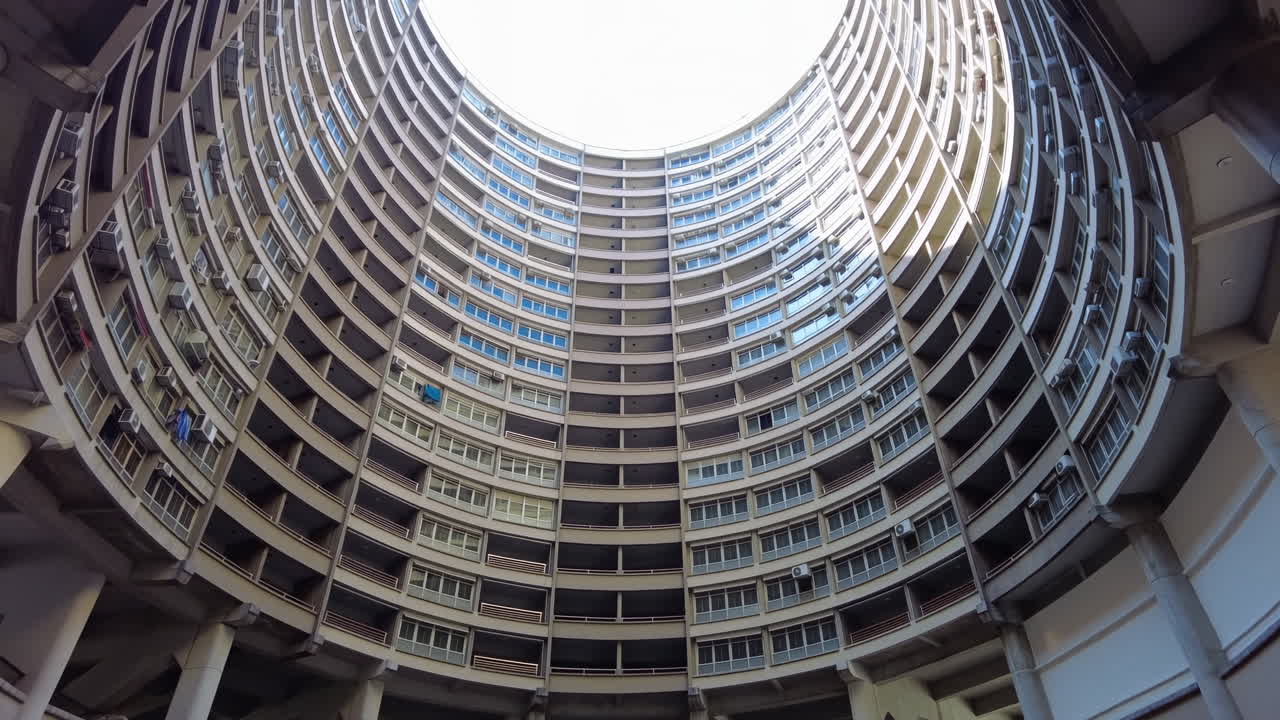 Vista verso l'alto di un condominio circolare con molti balconi