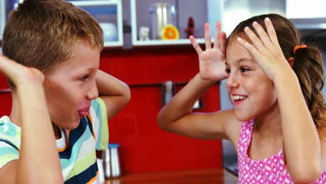 hermanos burlándose el uno del otro en la sala de estar