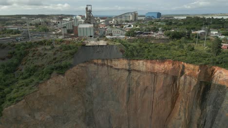 low aerial view of dangerous scaling erosion of open pit mine wall