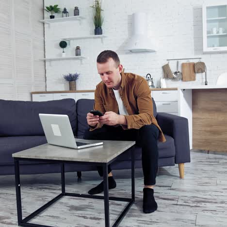 man works on laptop at home. young man working on laptop from home