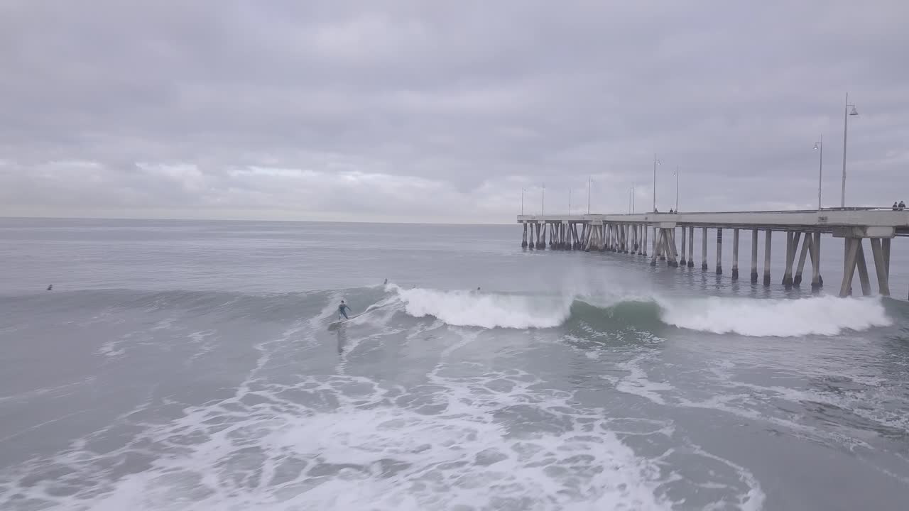 서퍼는 아침에 베니스 부두에서 파도를 잡는다