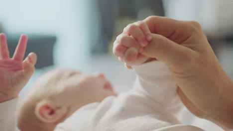 mother holding baby's hand