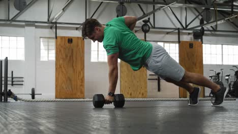 side view athletic caucasian man lifting alternate weights