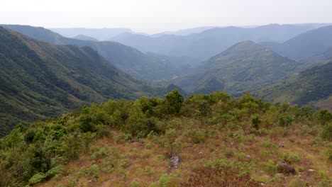 valle de montaña cubierto de bosques verdes y nieblas por la mañana desde un ángulo plano