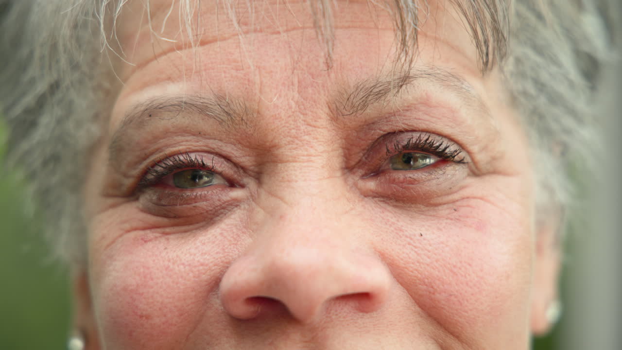 Smiling warmly, senior woman's eyes during family gathering, feeling joyful
