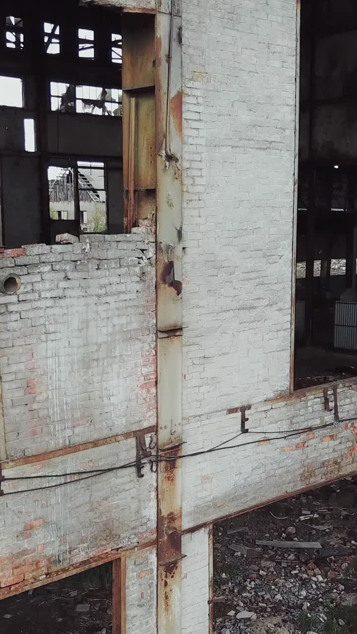 Aerial view of a destroyed factory during the war. Abandoned industrial building. Vertical video