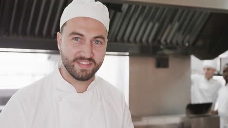 Retrato-De-Un-Feliz-Chef-Caucásico-Barbudo-Con-Sombrero-Sonriendo-En-La-Cocina,-Espacio-Para-Copiar,-Cámara-Lenta