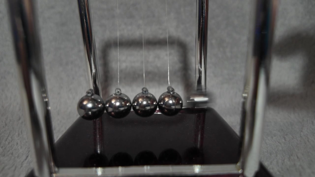 Toy slow motion pendulum showcasing energy and momentum transfer