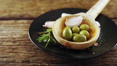 Zutaten-Oliven-Und-Knoblauch-Auf-Einem-Schwarzen-Teller-Aufbewahrt