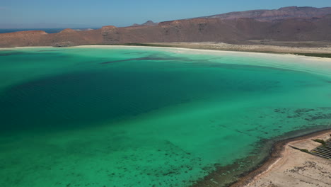 Cinematic-wide-drone-shot-of-Balandra-Beach,-view-turquoise-waters,-white-sand-beaches,-and-mountains,-wide-aerial-shot