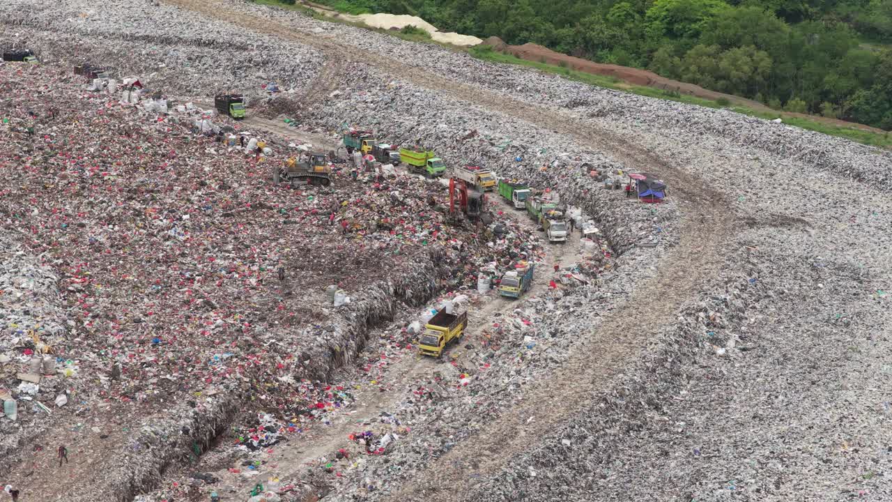 Vista aerea di autocarri per la raccolta rifiuti in una grande discarica.
